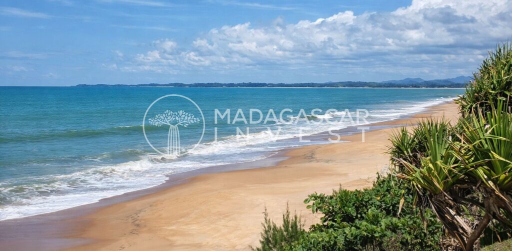 Image of a beachfront land near RFenerive Est showing the waves blowing over the beach with the Madagascar Invest logo watermark